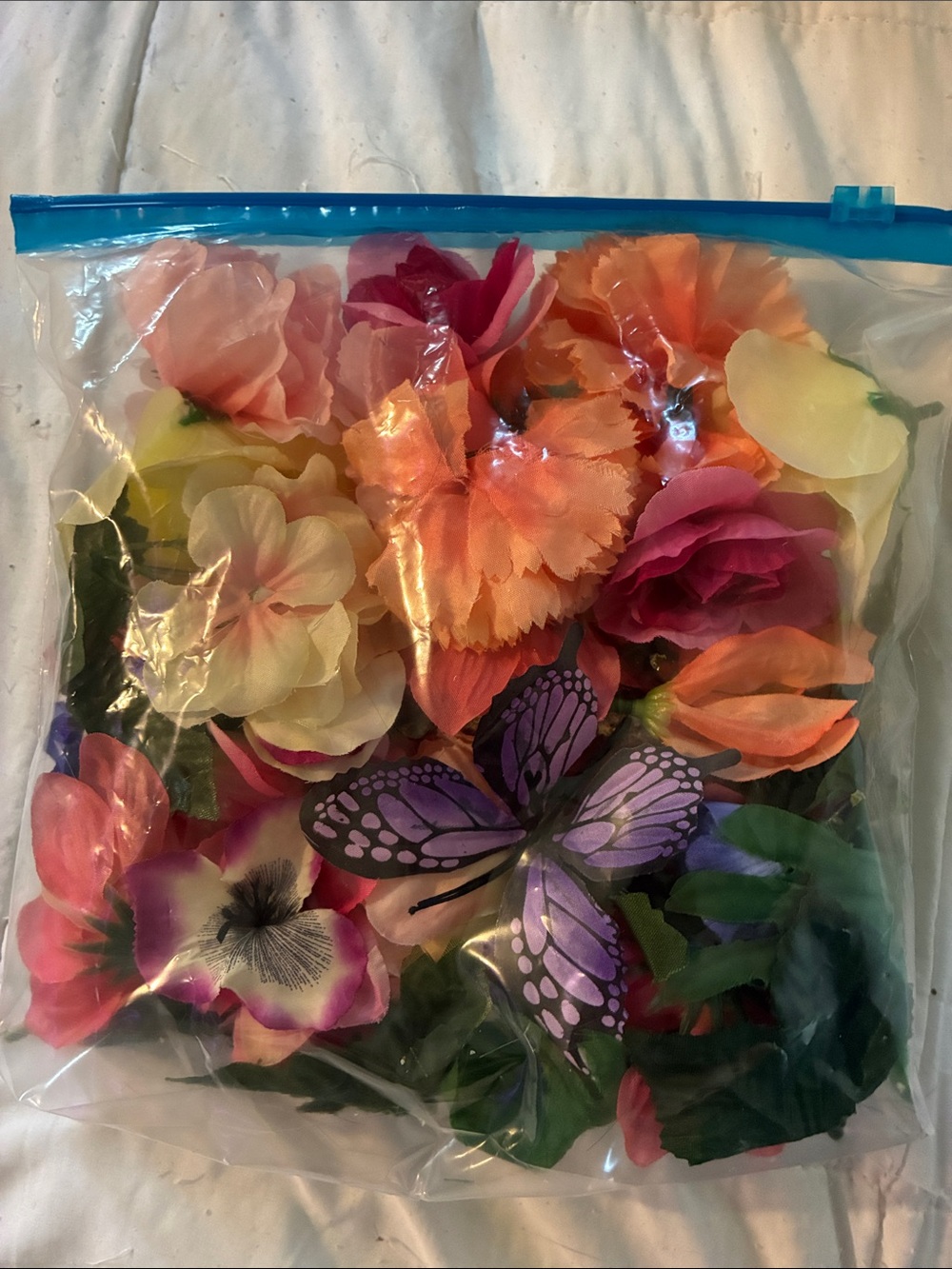 Mix of fake flowers, leaves and a butterfly